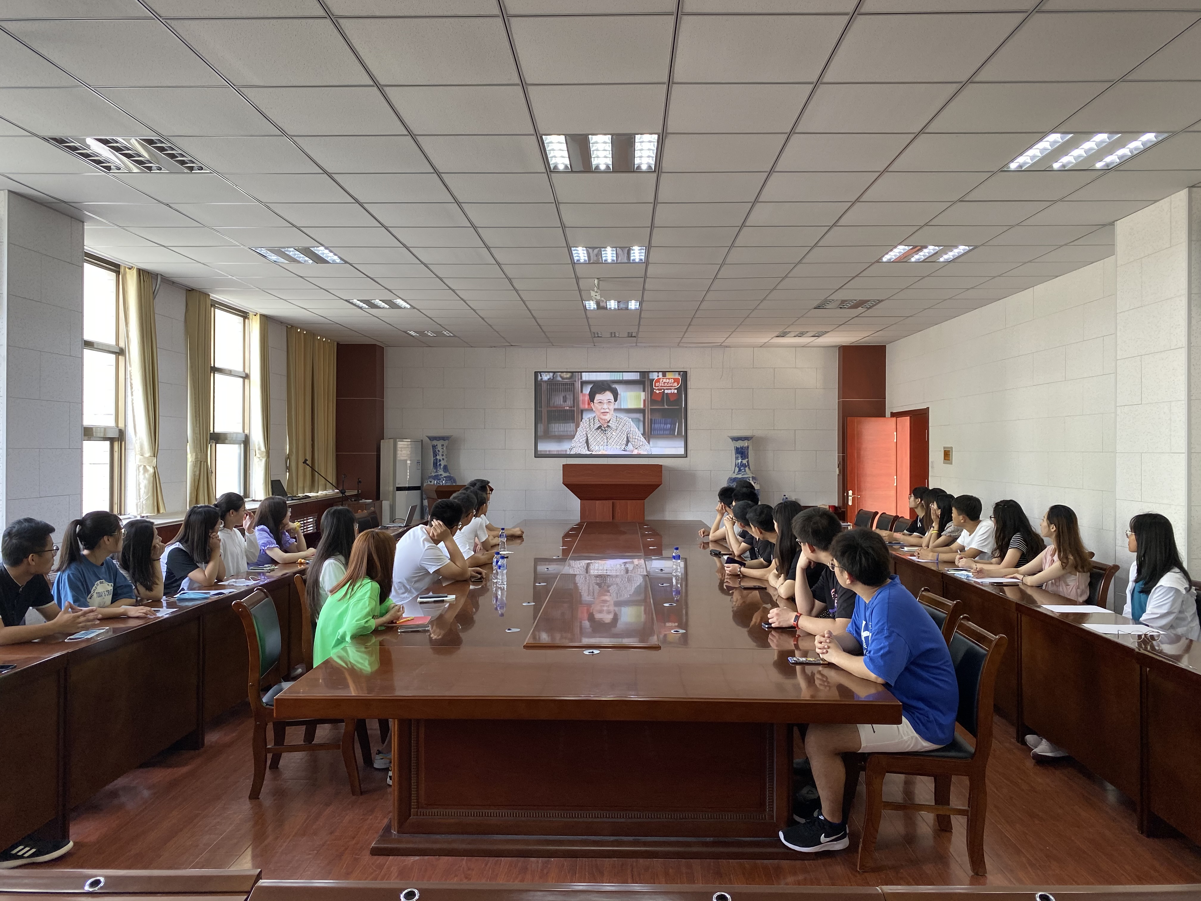 组织在学院教学楼办公的行政人员在会议室集中收看学习