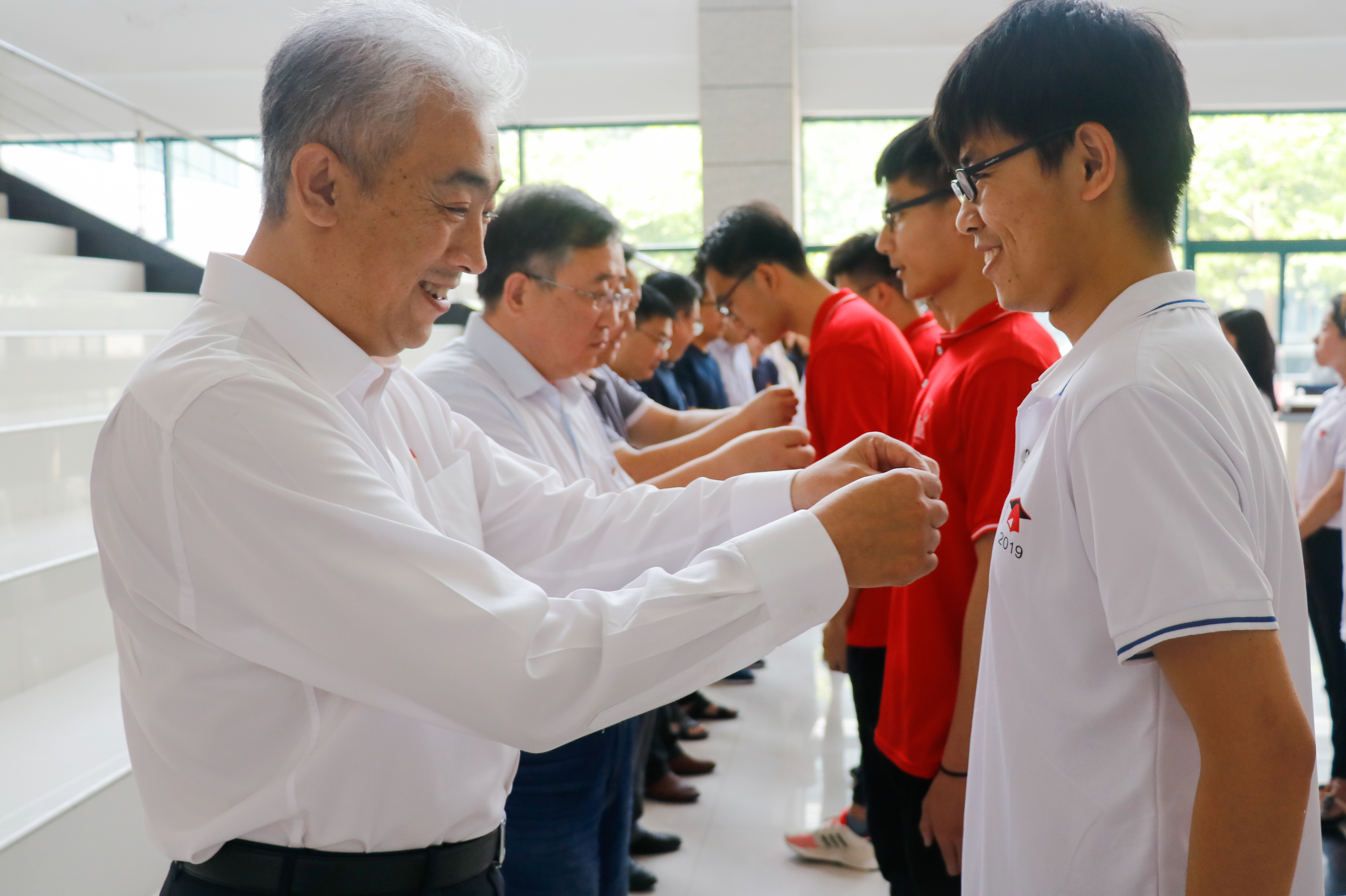 石工学院组织毕业生党员出征仪式，学院党委书记赵放辉为毕业生党员佩戴党徽