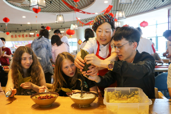 食堂阿姨指导留学生包粽子 侯王宇摄