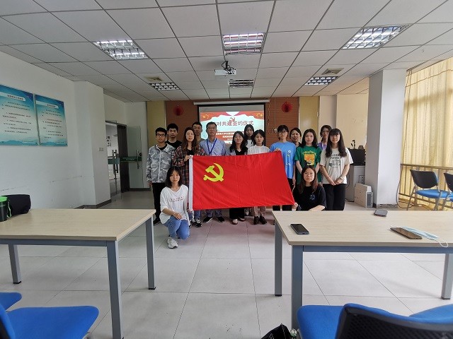 参与活动成员与党旗合影.jpg