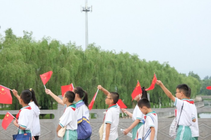 行进途中孩子们手舞国旗.jpg
