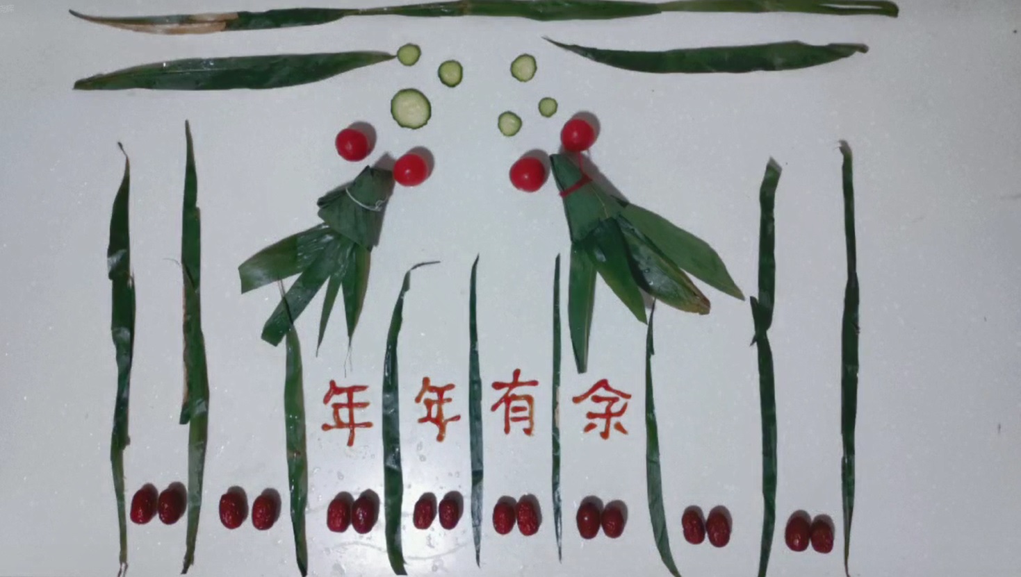 张晓辉老师用粽子摆出“年年有余”创意图案。粽子包含了中华传统,也使教职工能在包粽子中感受节日的快乐,体味美好生活。