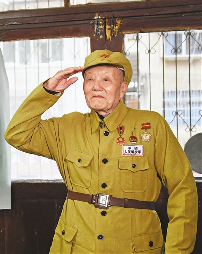 张富清穿着老式军装敬军礼。新华社记者 程 敏摄