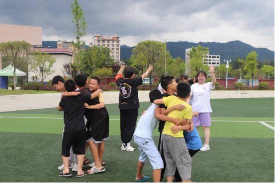 图为“爱的抱抱”破冰游戏中，三组学生努力抱团、相互合作，共同完成团队成员的指令.png