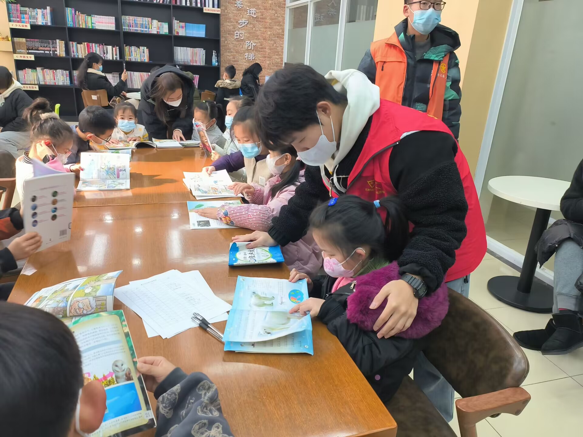 图为学生楼吴羽在江苏省苏州市相城区盛北花园六期社区居民委员会陪同小朋友一起开展社区读书交流会和课外讲座。