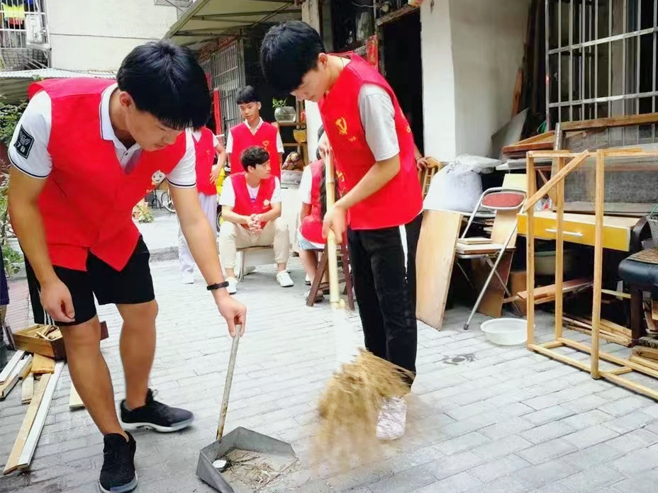 图为学生陈凯瑞在江苏省淮安市御景城社区进行寒假社会实践，他主要负责分发环境保护宣传单、清扫地面，保持社区环境整洁。