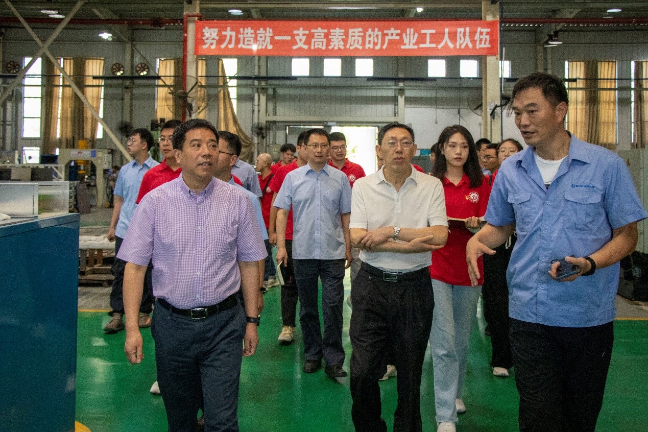 图为王国春书记带领实践队员们参观生产车间。.jpg 图为王国春书记带领实践队员们参观生产车间。.jpg