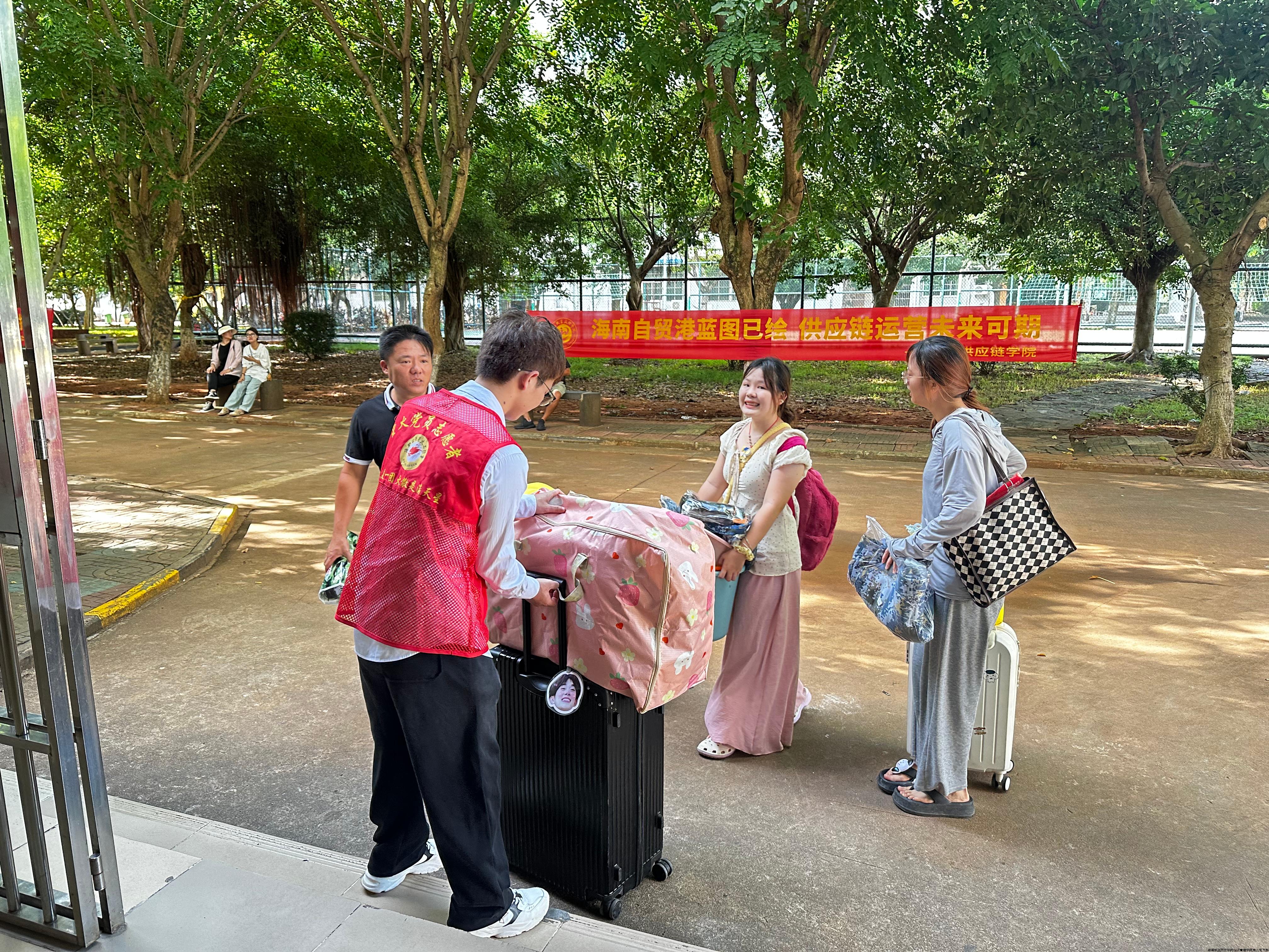 学生党员志愿者在帮助新生搬运行李到宿舍.jpg